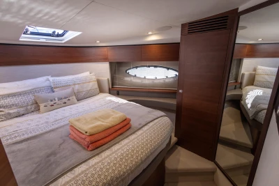 Luxurious bedroom interior of 2018 Princess 43 yacht with cozy bedding and elegant wood finishes.