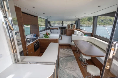 Luxurious interior of 2025 Princess F65 yacht with modern kitchen and seating area.