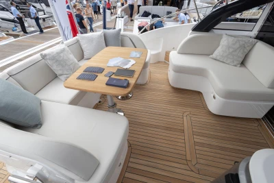 Luxurious seating area on 2023 Princess V50 yacht with wooden deck and cushions.