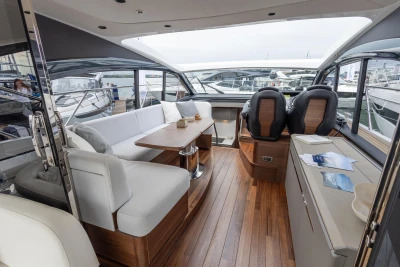 Luxurious 2023 Princess V50 yacht interior with elegant seating and wooden flooring.