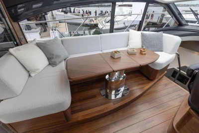 Luxurious interior of 2023 Princess V50 yacht with elegant seating and wooden table.