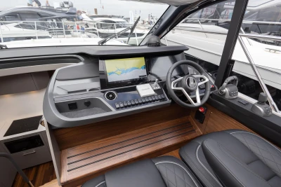 Helm of 2023 Princess V50 yacht with modern navigation system and luxurious seating.