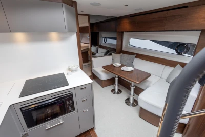 Luxurious interior of 2023 Princess V50 yacht with modern kitchen and cozy seating area.