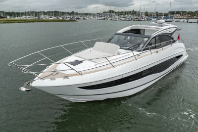 2023 Princess V50 yacht cruising in a marina, showcasing sleek design and luxury features.