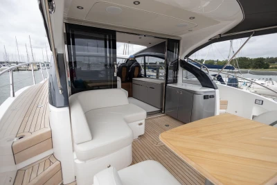 Luxurious 2023 Princess V50 yacht interior with seating and dining area.