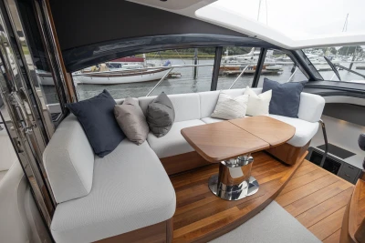 Luxurious interior of 2023 Princess V50 yacht with elegant seating and wooden table.