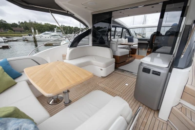 Luxurious 2023 Princess V50 yacht interior with elegant seating and wooden table.