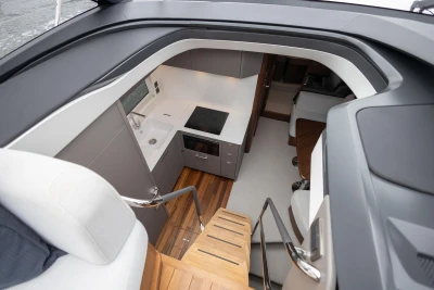 Modern interior of 2023 Princess V50 yacht with sleek kitchen and wooden stairs.
