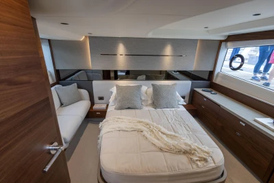 Luxurious 2023 Princess V50 yacht bedroom with elegant decor and large window view.