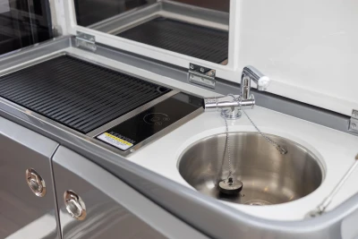 Modern kitchen area in 2023 Princess V50 yacht with sink and stovetop.