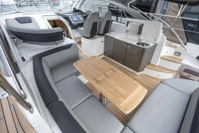 Luxurious 2018 Princess V40 yacht interior with seating, table, and kitchenette.