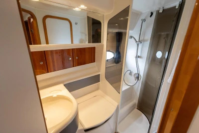 Luxurious bathroom in 2000 Princess V42 yacht with shower and wooden cabinets.