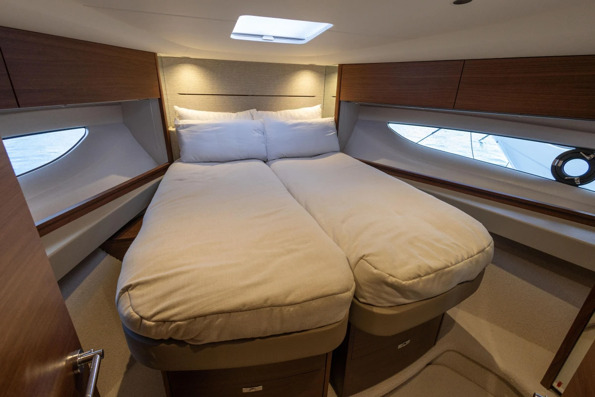 Luxurious cabin interior of 2024 Princess V50 Open yacht with cozy bedding.