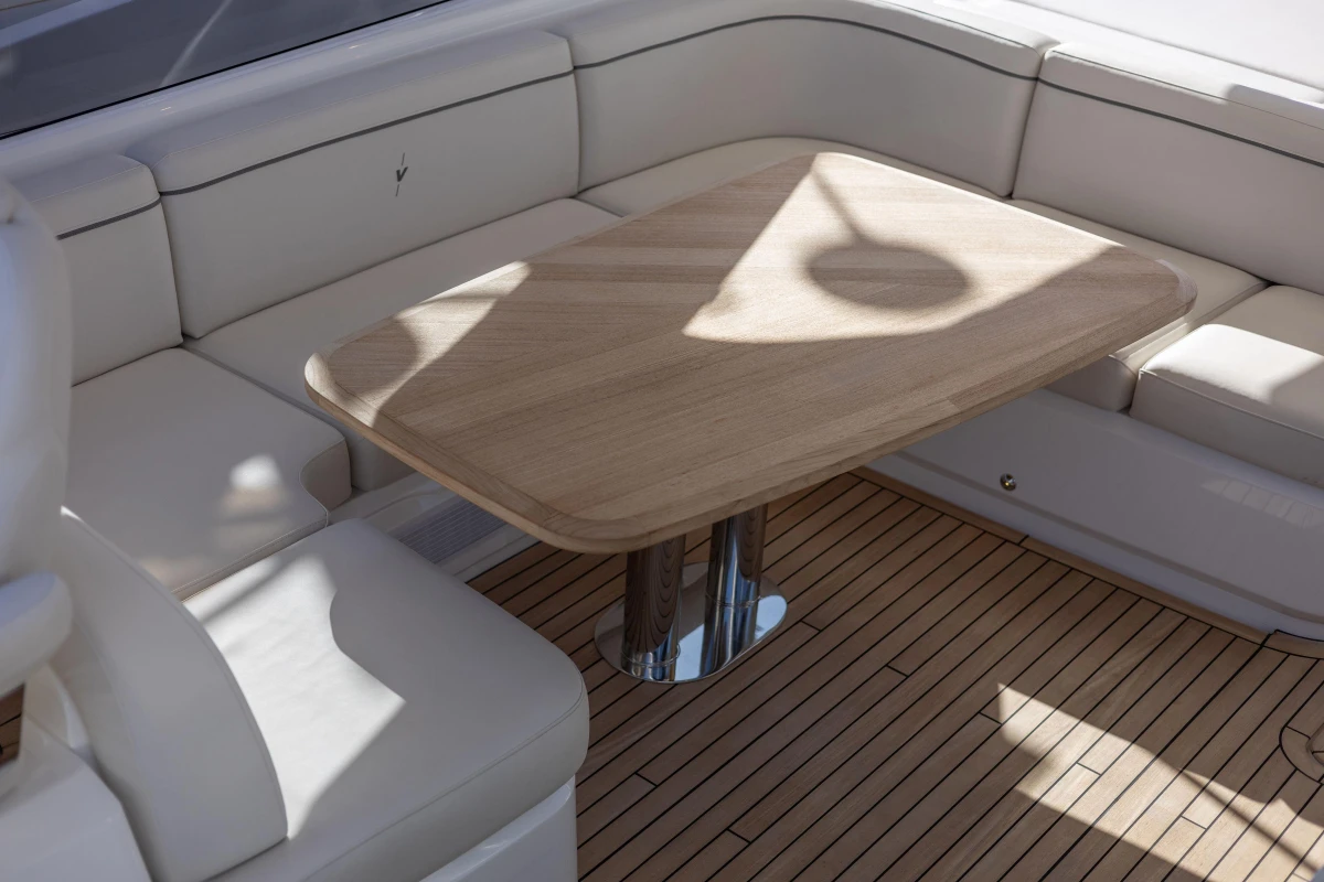 Luxurious seating area on 2024 Princess V50 Open yacht with wooden table.