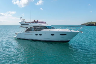 Luxury 2015 Princess 43 yacht cruising on clear blue waters.