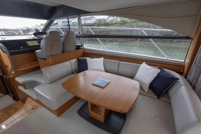 Luxurious interior of 2015 Princess 43 yacht with elegant seating and scenic window view.