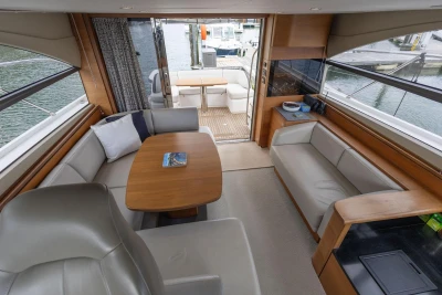 Luxurious interior of 2015 Princess 43 yacht with elegant seating and wooden table.