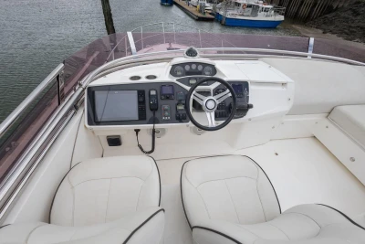 Luxurious helm of a 2015 Princess 43 yacht with modern navigation equipment and plush seating.