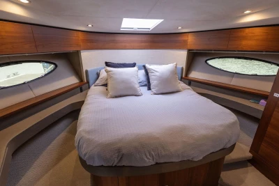 Luxurious cabin interior of a 2015 Princess 43 yacht with elegant bedding.