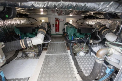 Engine room of a 2015 Princess 43 yacht, featuring dual engines and metallic flooring.