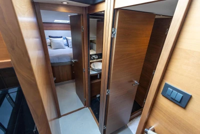 Luxurious interior of 2015 Princess 43 yacht featuring bedroom and bathroom with wooden finishes.