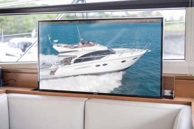 Luxurious Princess 43 yacht interior with TV displaying yacht cruising on water, 2015 model.