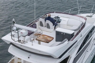 Flybridge of 2017 Princess 43 yacht with captain navigating on open water.