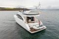 Luxury 2017 Princess 43 yacht on serene water, rear view with tender boat.