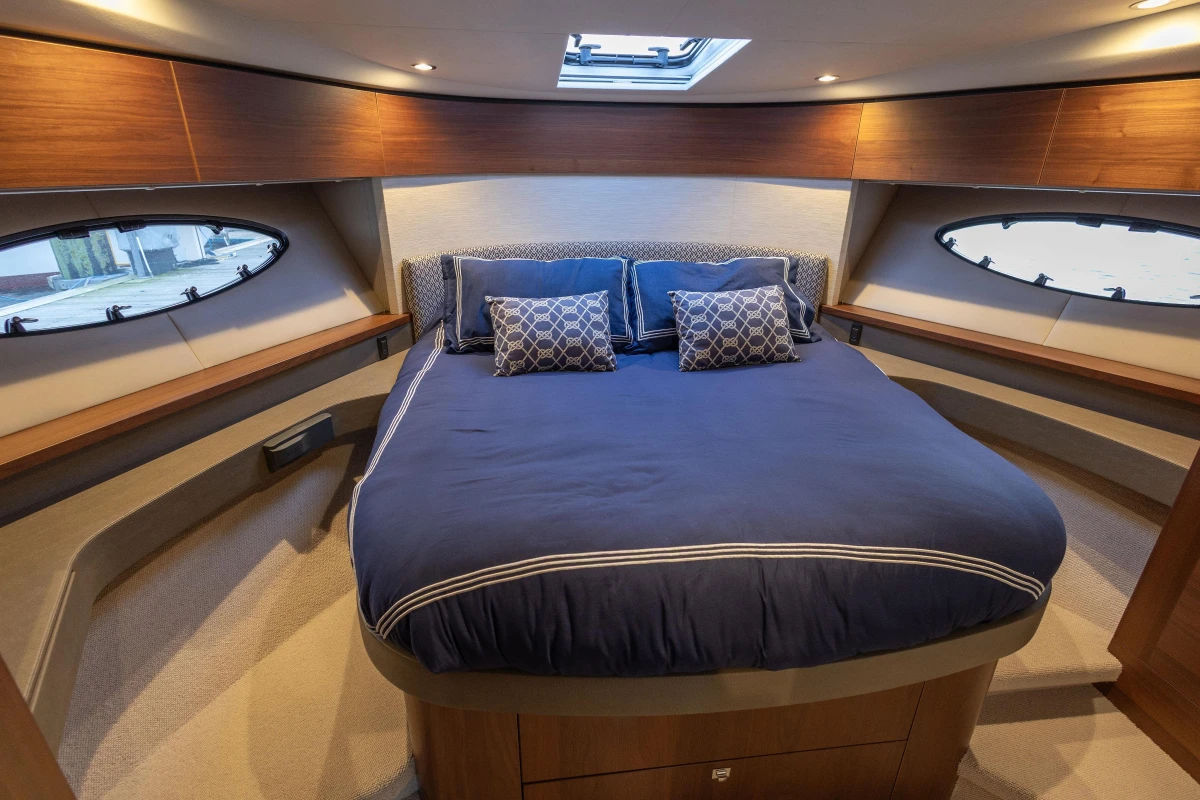 Luxurious cabin interior of 2017 Princess 43 yacht with elegant bedding and wood accents.
