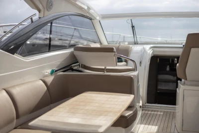 Interior of 2014 Princess V39 yacht with beige seating and wooden table.