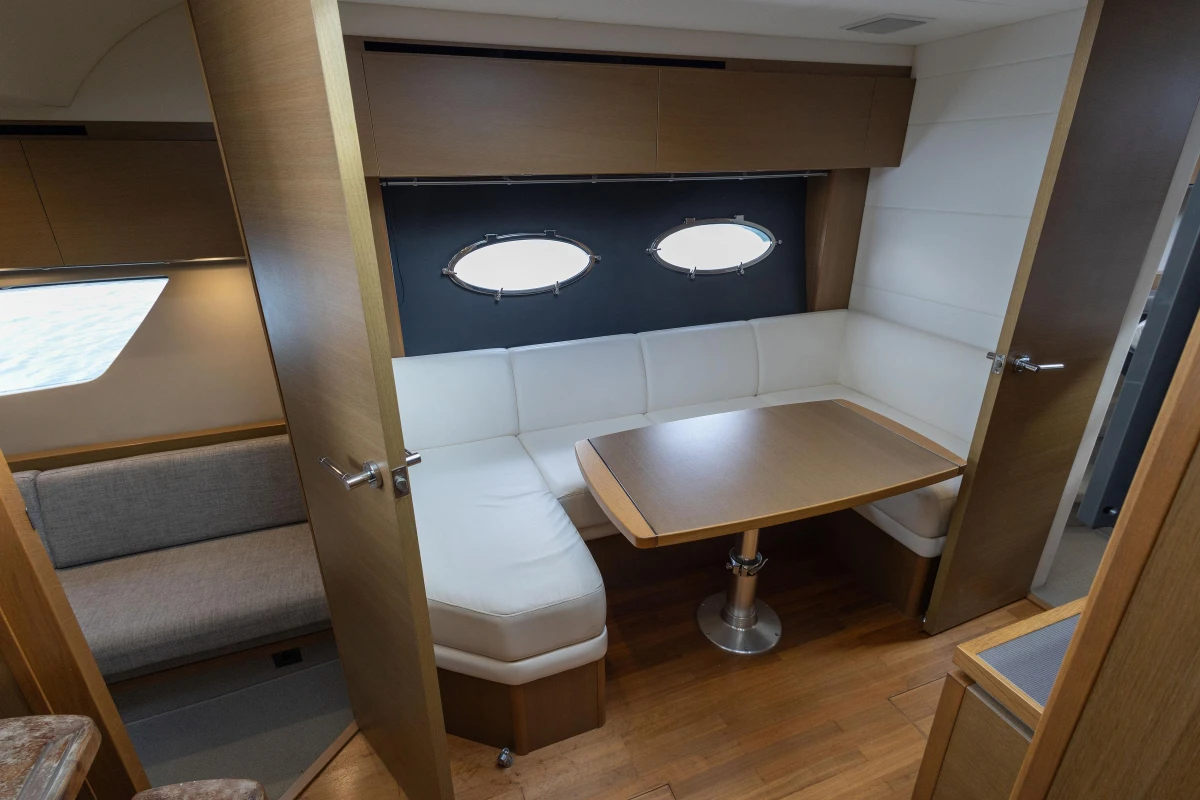Interior of 2014 Princess V39 yacht with cozy seating and wooden table.
