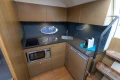 Compact kitchen in a 2014 Princess V39 yacht with modern appliances and wood cabinetry.