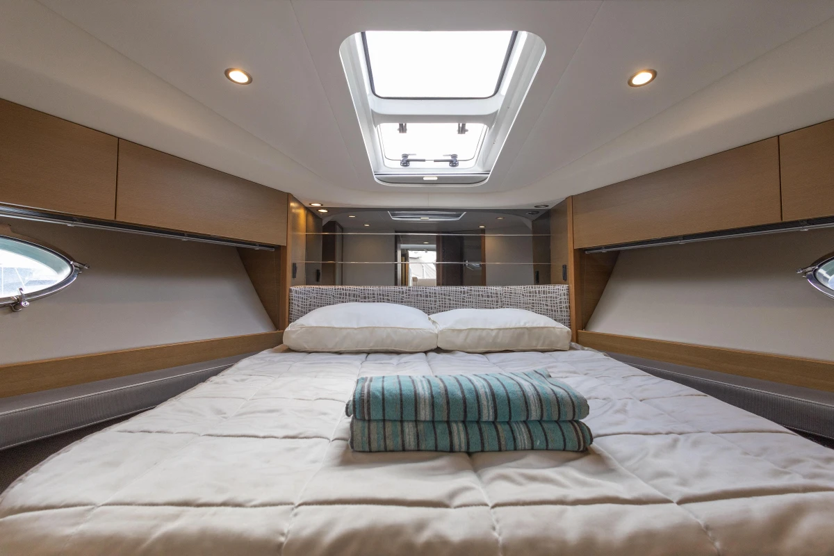 Luxurious cabin interior of 2014 Princess V39 yacht with skylight and cozy bedding.