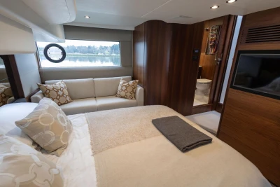 Luxurious interior of 2018 Princess 49 yacht with cozy bedroom and elegant furnishings.