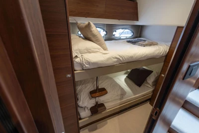 Luxurious 2018 Princess 49 yacht cabin with cozy bunk beds and elegant wood finish.