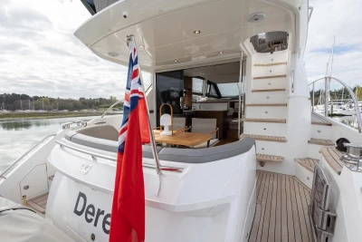 Luxurious 2018 Princess 49 yacht with elegant deck and seating area, docked at marina.