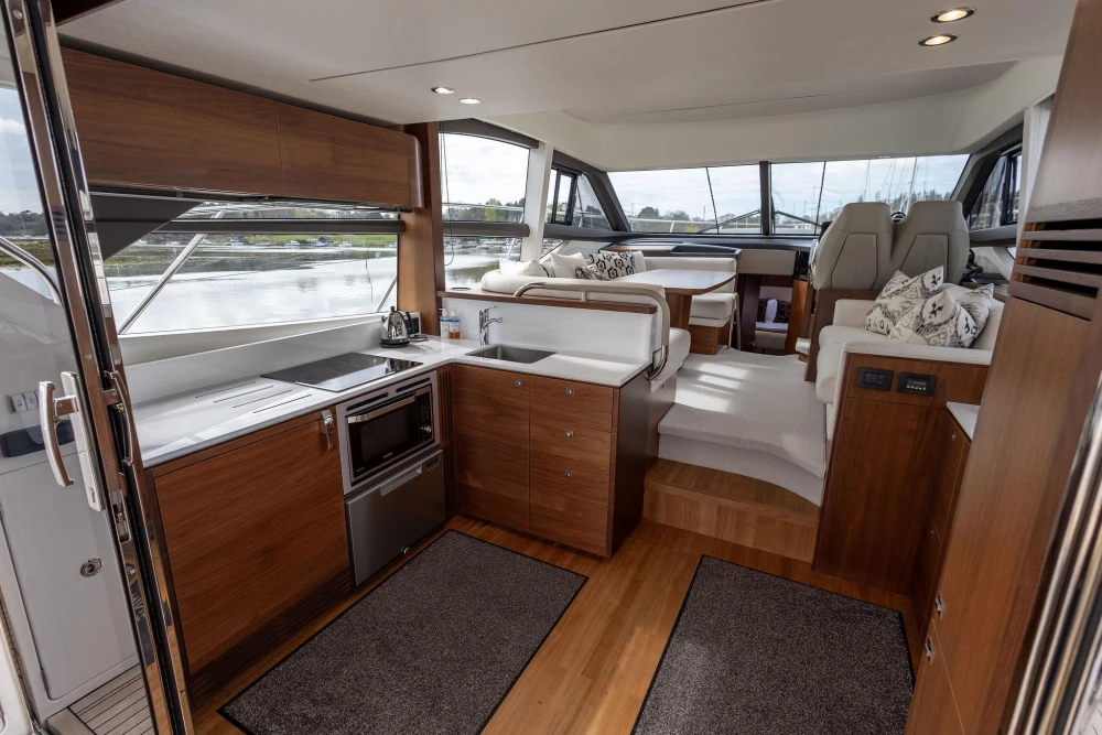 Luxurious interior of a 2018 Princess 49 yacht with modern kitchen and seating area.