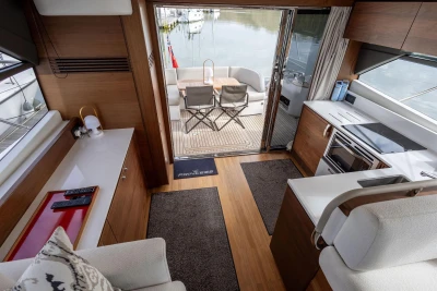 Luxurious interior of 2018 Princess 49 yacht with modern kitchen and outdoor seating area.