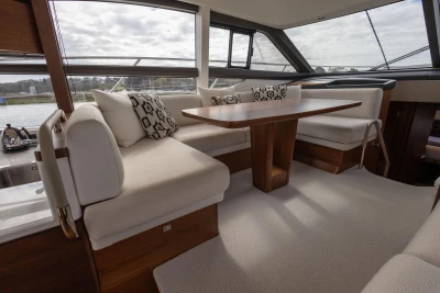 Luxurious interior of 2018 Princess 49 yacht with elegant seating and wooden table.