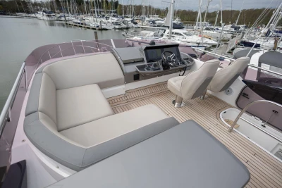 Luxurious 2018 Princess 49 yacht interior with plush seating and modern helm, docked at marina.