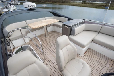Luxurious 2018 Princess 49 yacht deck with seating, table, and scenic water view.