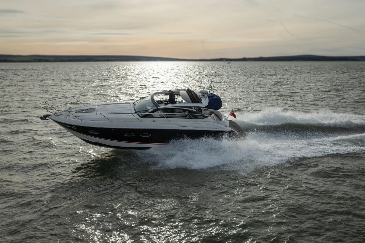 2013 Princess V39 yacht cruising on open water at sunset.