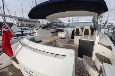 2013 Princess V39 yacht with spacious deck, seating, and canopy in marina setting.