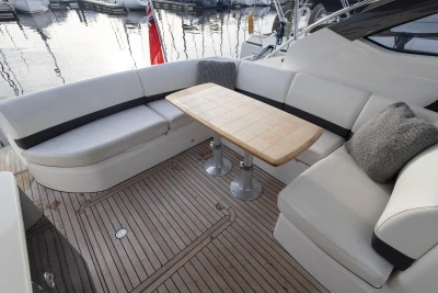 Luxurious seating area on 2013 Princess V39 yacht with wooden table and plush cushions.