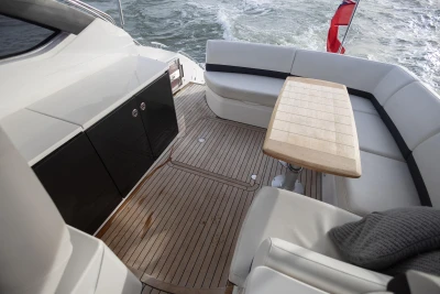 2013 Princess V39 yacht deck with seating and table, cruising on water.
