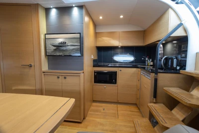 Luxurious 2013 Princess V39 yacht interior with modern kitchen and wooden cabinetry.