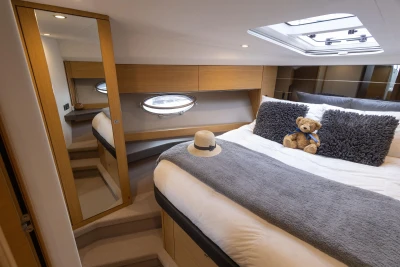 Luxurious cabin interior of 2013 Princess V39 yacht with plush bedding and skylight.