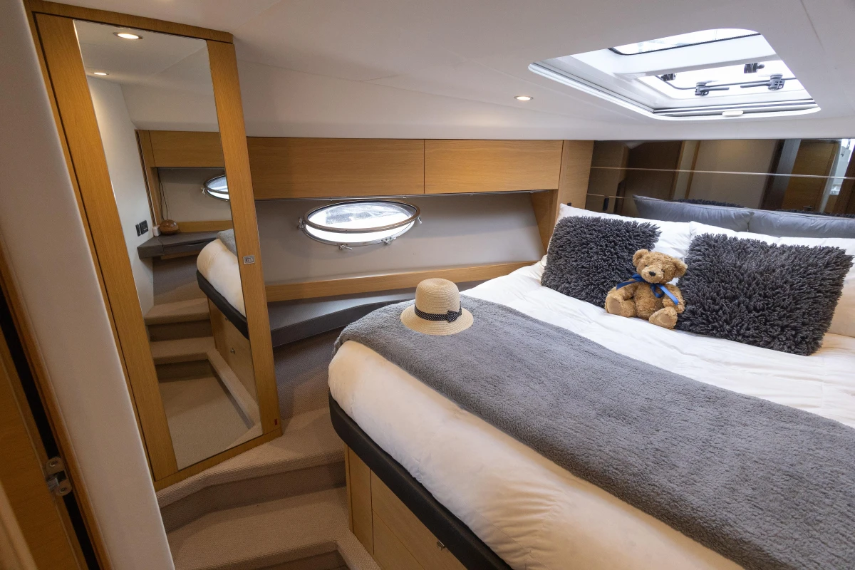 Luxurious cabin interior of 2013 Princess V39 yacht with plush bedding and skylight.