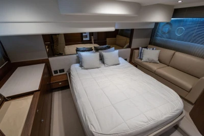 Luxurious bedroom interior of 2017 Princess 49 yacht with bed, sofa, and elegant decor.