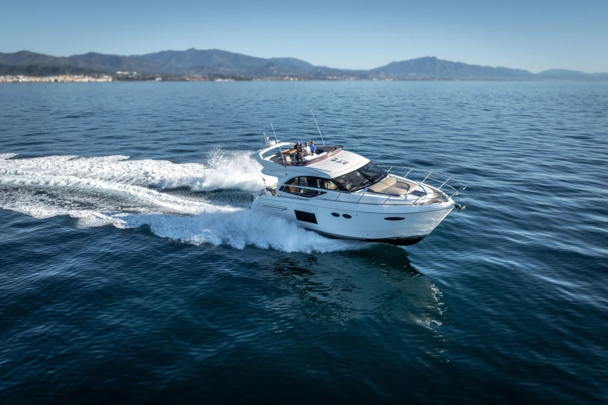 2017 Princess 49 yacht cruising on open water with scenic mountain backdrop.